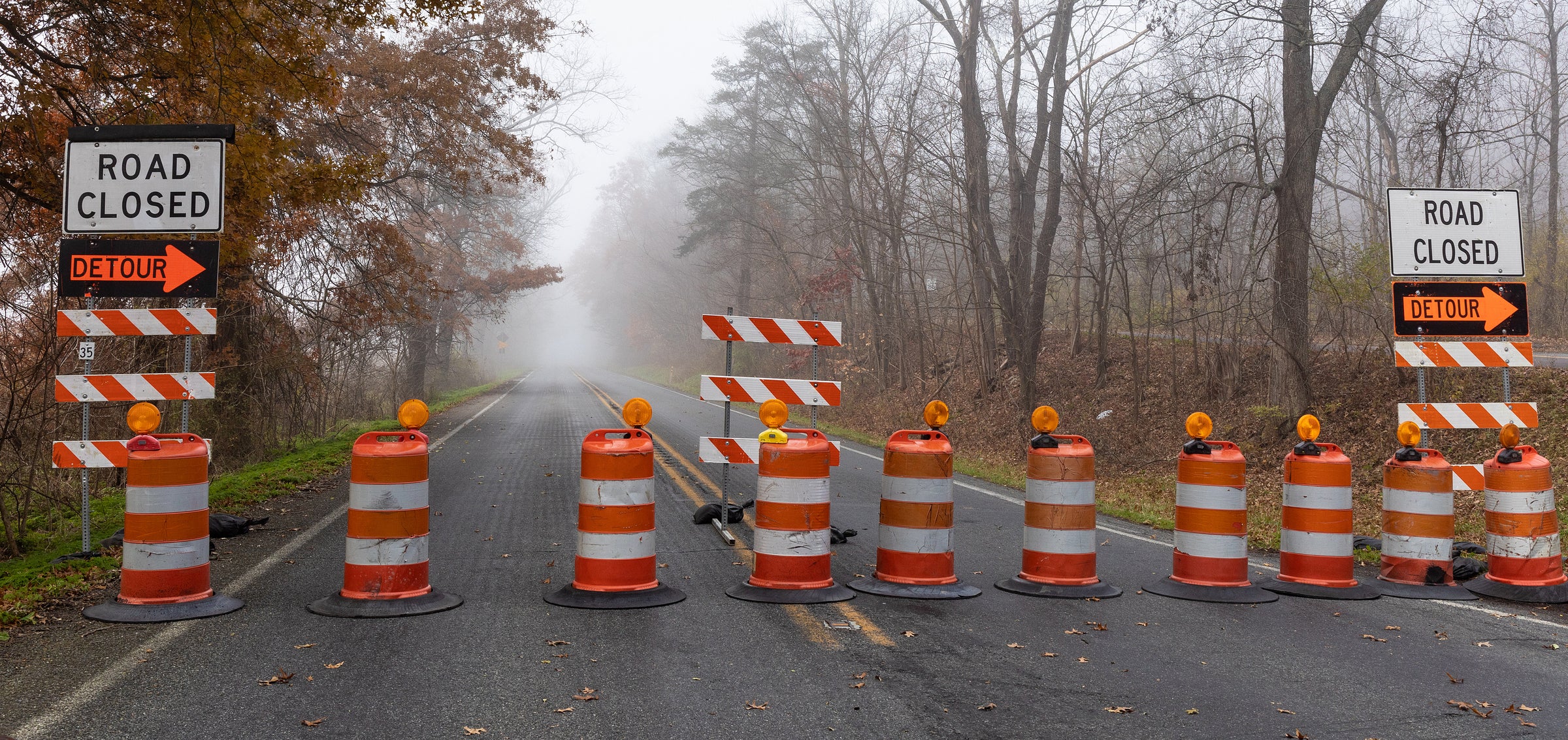 Channelizer Drums with Lights Barricades and Signs Road Closed Image